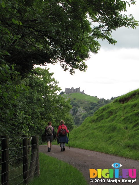 SX16181 Jenni and Margaret walking on road back towards Carreg Cennen Castle on top of distant cliffs
